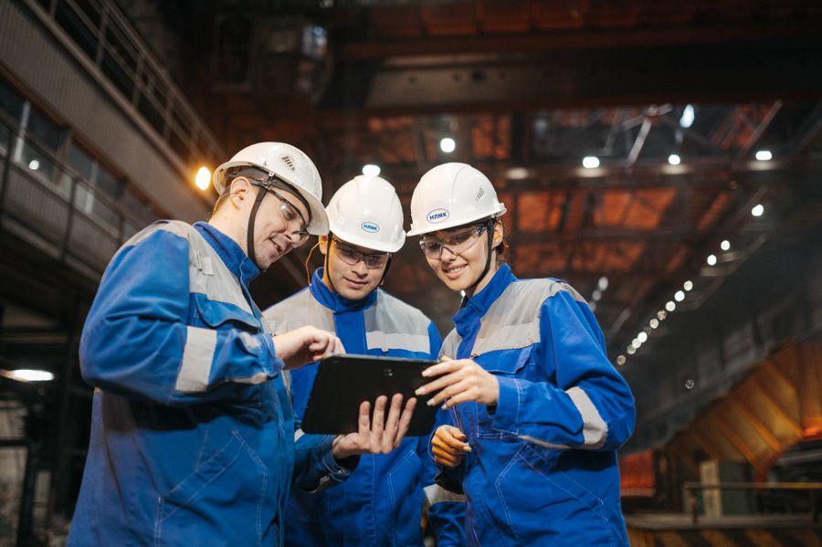Profissionais de engenharia discutindo o trabalho com um tablet na fábrica
